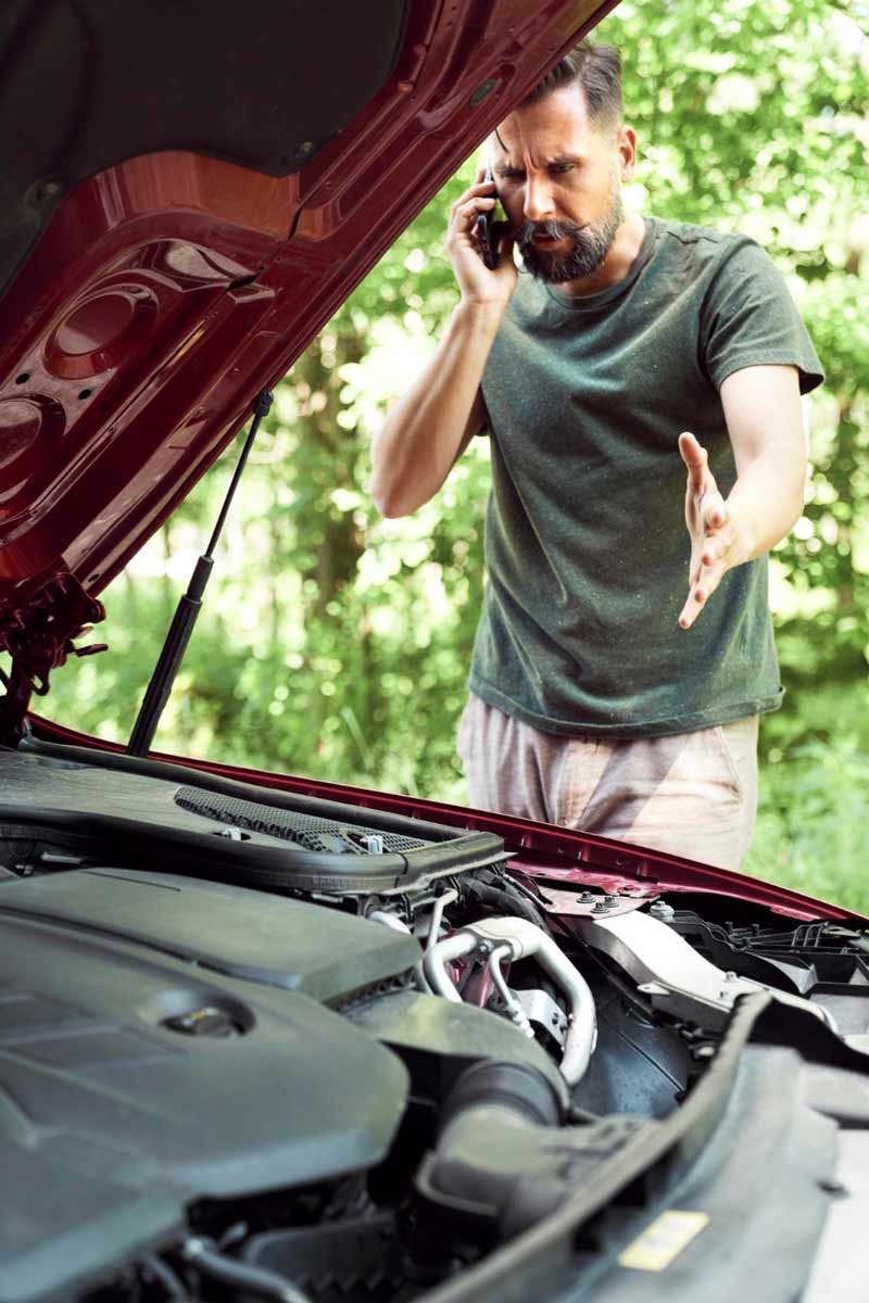 Junger Mann prüft Getriebeschaden bei Schrottauto Ankauf Bergkamen